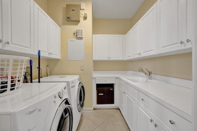 laundry area with cabinets, light tile patterned flooring, sink, and separate washer and dryer