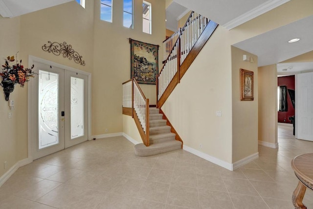 tiled entryway with a high ceiling, french doors, and crown molding