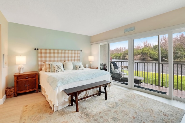 bedroom with access to outside and light hardwood / wood-style floors