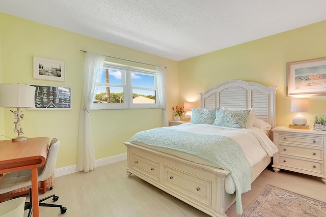 bedroom featuring a textured ceiling and light hardwood / wood-style flooring