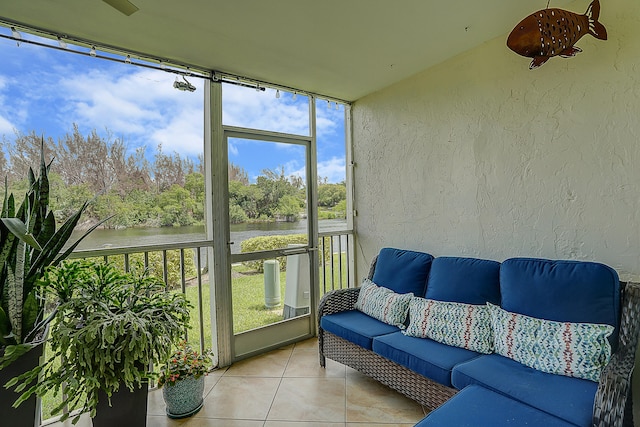 sunroom featuring a water view