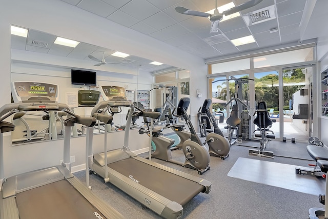 gym with a paneled ceiling and ceiling fan