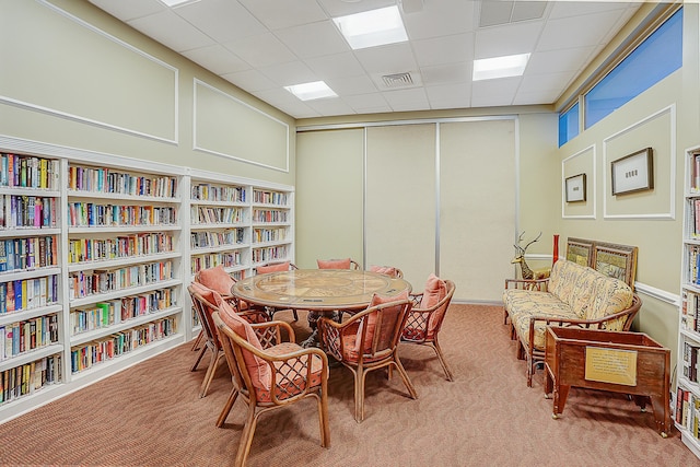 dining room featuring carpet and a drop ceiling