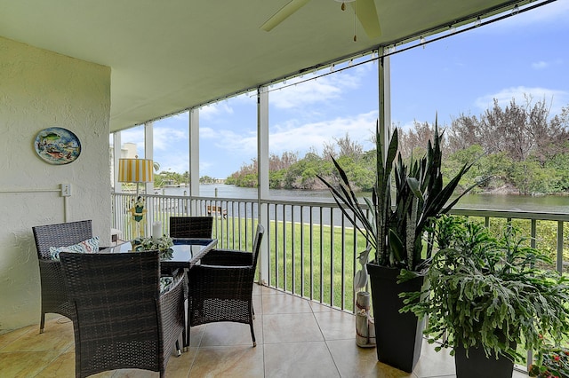 sunroom / solarium with a water view and ceiling fan