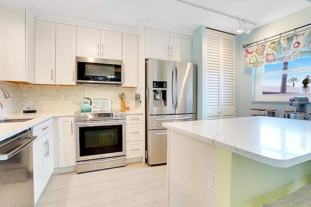 kitchen featuring white cabinets, decorative backsplash, sink, and stainless steel appliances