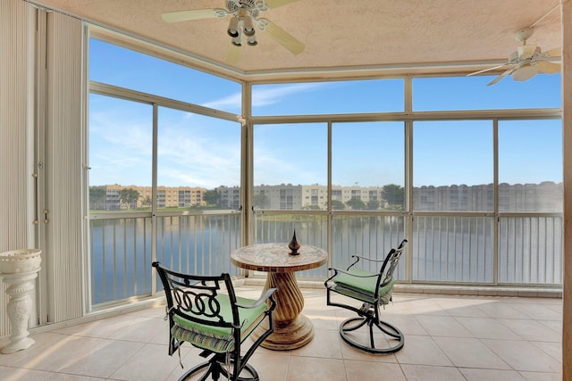 sunroom / solarium with a water view and ceiling fan