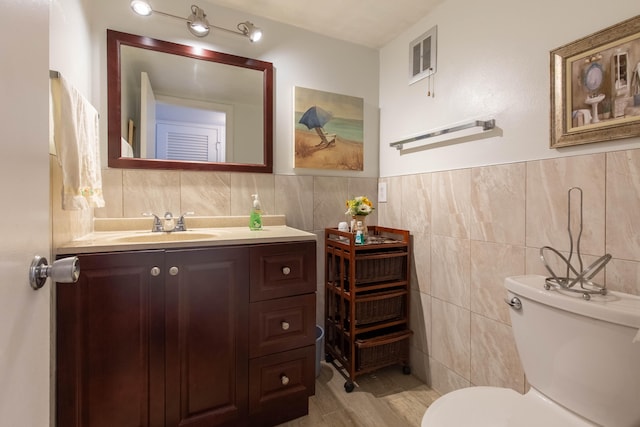 bathroom featuring tile walls, hardwood / wood-style flooring, and toilet