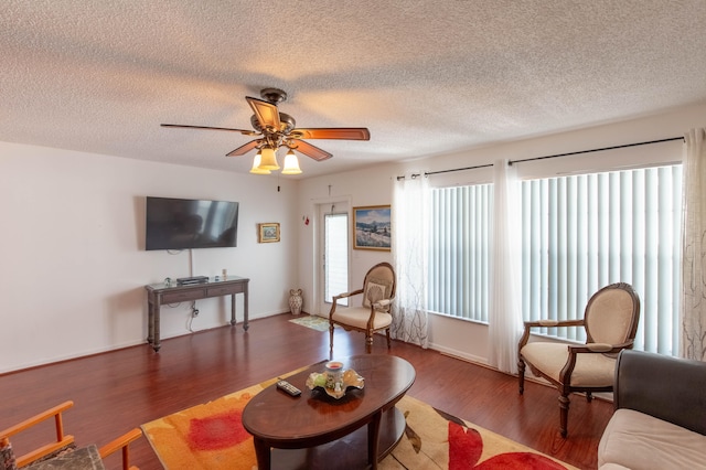 living room featuring ceiling fan, wood-type flooring, and a textured ceiling