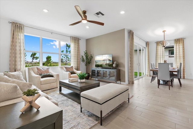 living room with ceiling fan and light hardwood / wood-style flooring