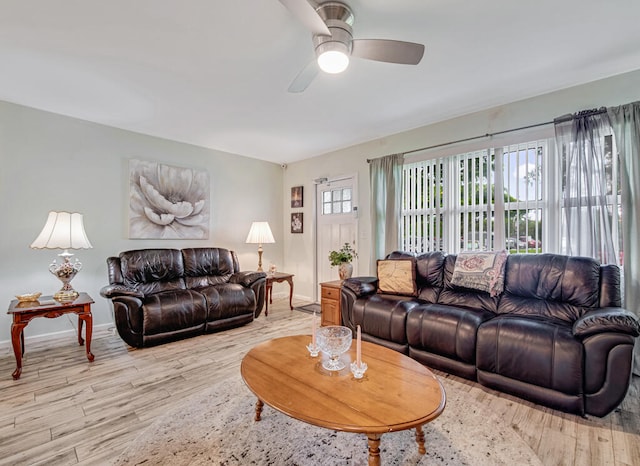 living room with light hardwood / wood-style flooring, ceiling fan, and a healthy amount of sunlight