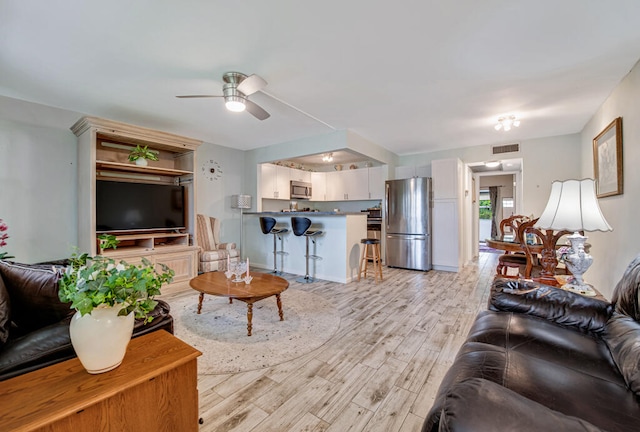 living room featuring ceiling fan and light hardwood / wood-style flooring