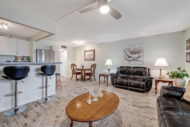 living room with light hardwood / wood-style flooring and ceiling fan