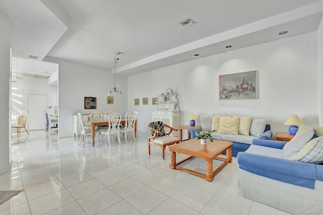 living room featuring a notable chandelier and light tile patterned flooring