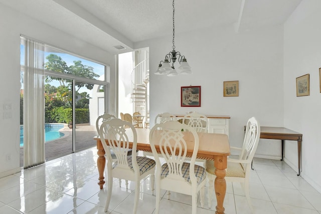 dining room featuring light tile patterned flooring, a textured ceiling, and an inviting chandelier