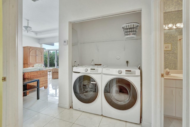 laundry room with light tile patterned floors, sink, ceiling fan, and washing machine and clothes dryer