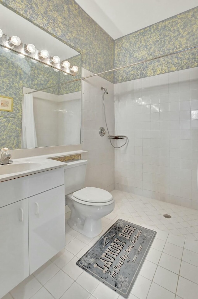 bathroom with tile patterned flooring, vanity, toilet, and walk in shower