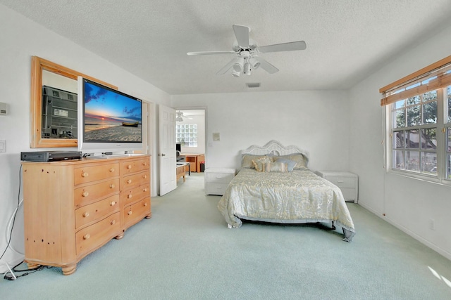 bedroom with carpet, ceiling fan, and a textured ceiling