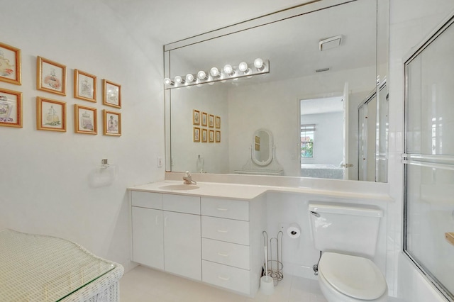 full bathroom with tile patterned floors, vanity, combined bath / shower with glass door, and toilet