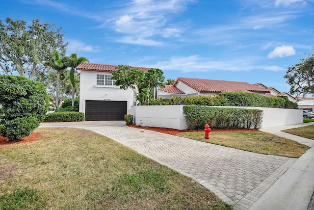 mediterranean / spanish-style home featuring a garage and a front yard