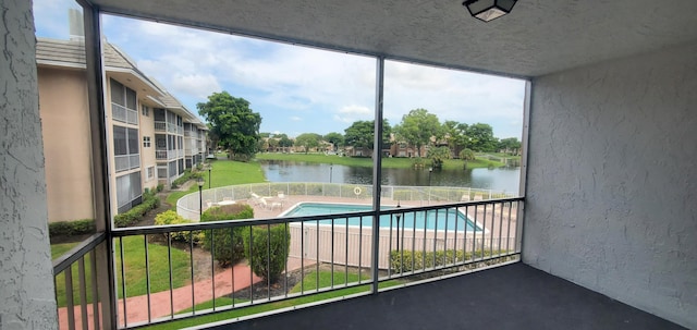 unfurnished sunroom featuring a water view