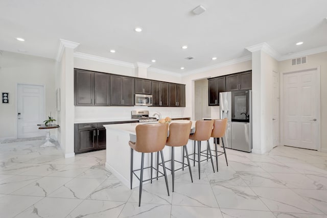 kitchen featuring stainless steel appliances, crown molding, light tile patterned flooring, and an island with sink