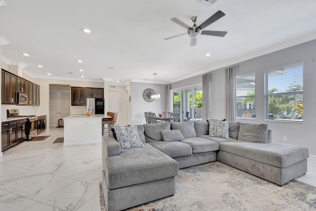 tiled living room with ceiling fan, sink, and crown molding