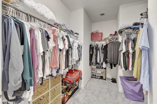 walk in closet with light colored carpet