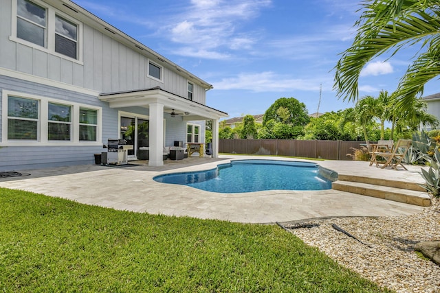 view of pool featuring ceiling fan, a yard, a patio, and area for grilling