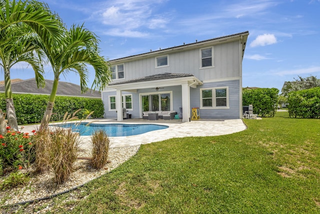 back of house with ceiling fan, a fenced in pool, a patio area, and a yard