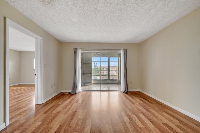 empty room featuring light hardwood / wood-style flooring and a textured ceiling