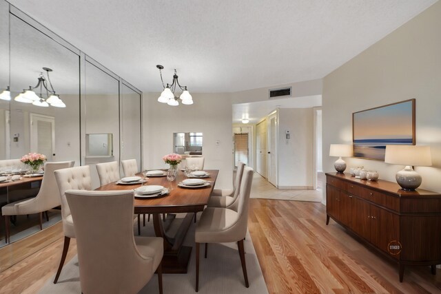 dining room with light hardwood / wood-style flooring and a chandelier