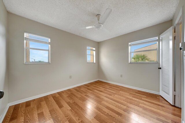 unfurnished bedroom with ceiling fan, a textured ceiling, and light hardwood / wood-style floors