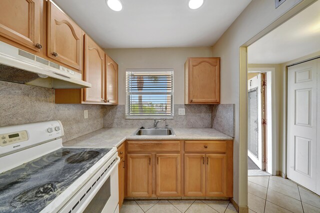 kitchen with sink, backsplash, light tile patterned floors, and white electric stove