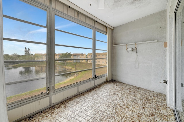 unfurnished sunroom featuring a water view