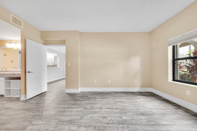 unfurnished room with sink and hardwood / wood-style flooring