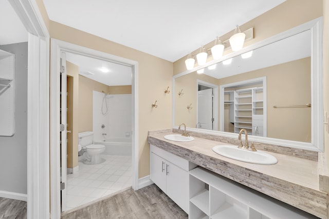 full bathroom featuring wood-type flooring, tub / shower combination, double sink vanity, and toilet