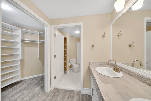 bathroom featuring toilet, vanity, and hardwood / wood-style flooring