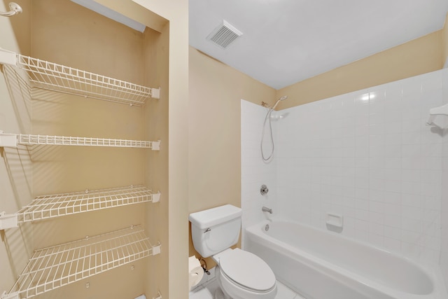 bathroom featuring tiled shower / bath and toilet