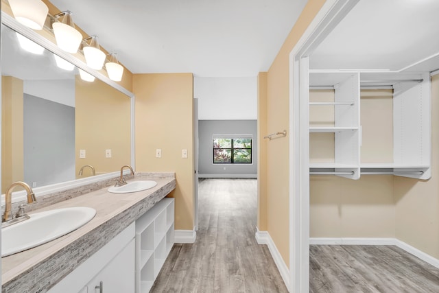 bathroom with dual vanity and wood-type flooring