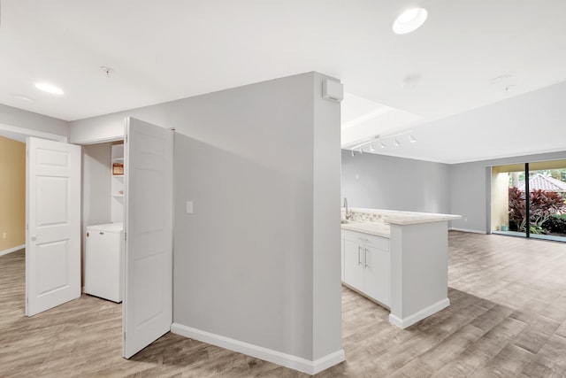 interior space with light hardwood / wood-style flooring, sink, and washer / dryer