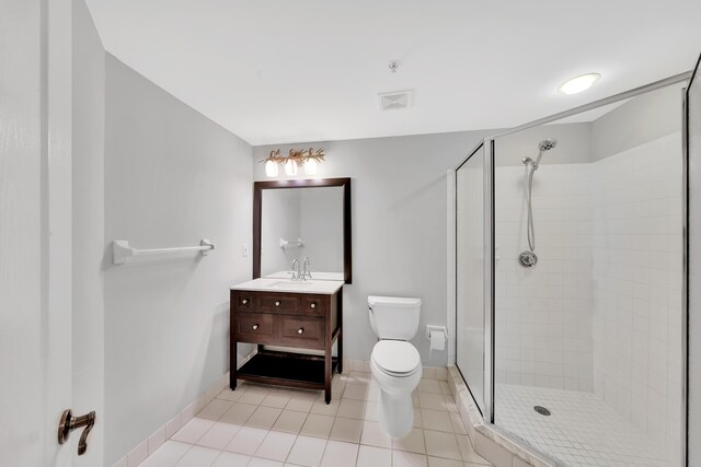 bathroom with an enclosed shower, tile patterned floors, vanity, and toilet