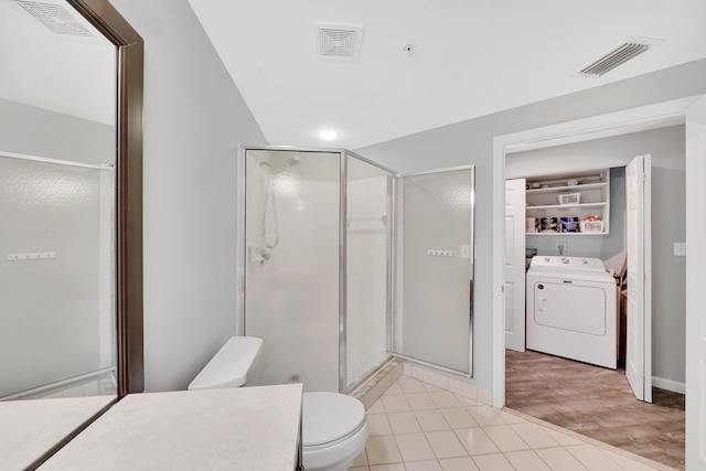 bathroom with toilet, washer / dryer, tile patterned flooring, walk in shower, and vanity