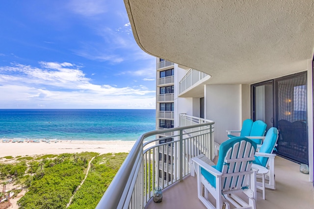 balcony featuring a water view and a view of the beach