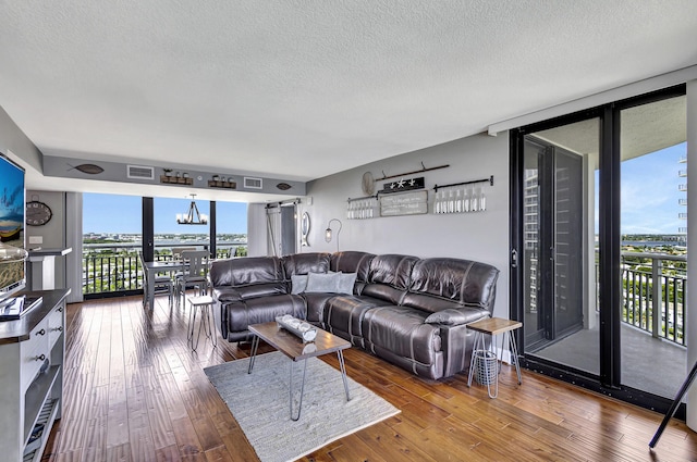 living room featuring a wall of windows, plenty of natural light, and hardwood / wood-style floors