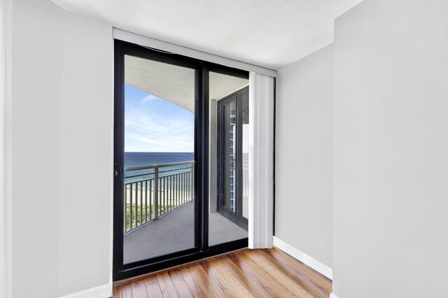 spare room with a water view and wood-type flooring