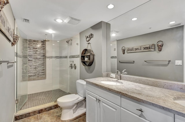 bathroom featuring tile patterned flooring, vanity, toilet, and a shower with shower door