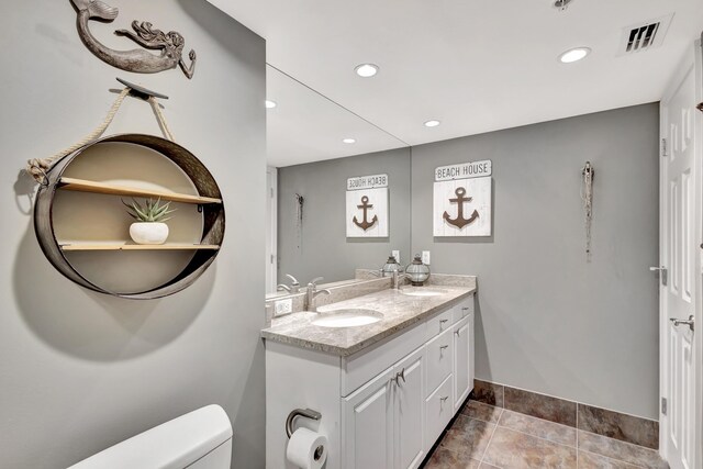 bathroom with tile patterned floors, dual bowl vanity, and toilet