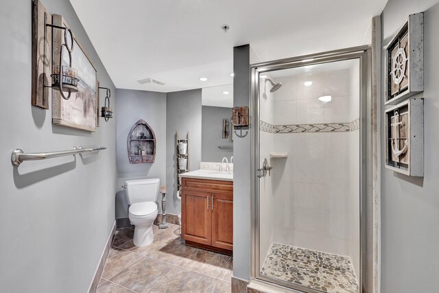 bathroom featuring tile patterned floors, vanity, walk in shower, and toilet