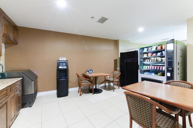 kitchen with black fridge and light tile patterned floors