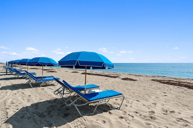 view of property's community with a water view and a beach view